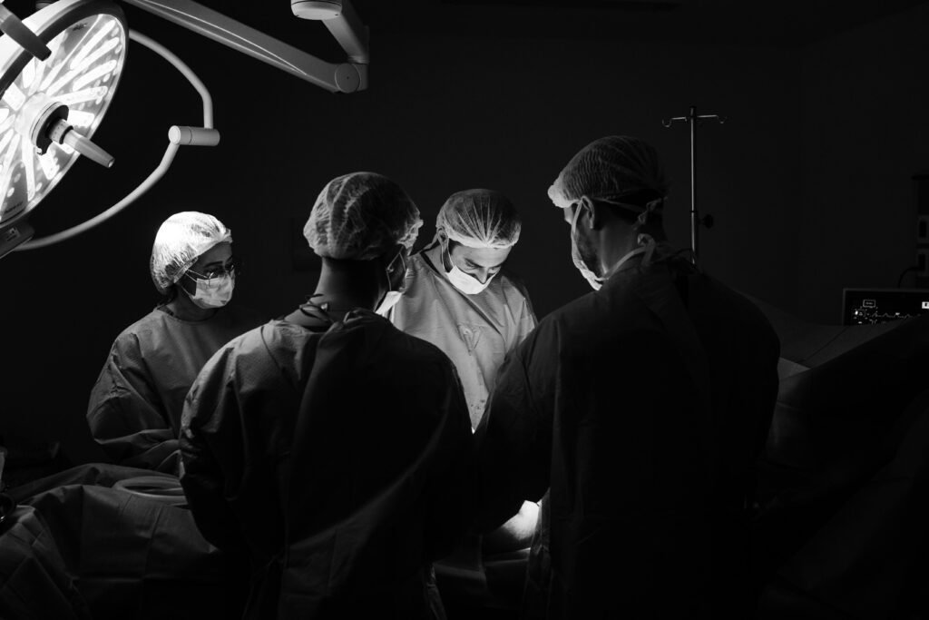 A group of surgeons in an operating room, focusing intently during a procedure.